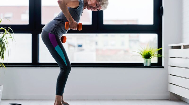 Mujer entrenando con mancuernas: ganar músculo es la única forma real de subir el metabolismo basal