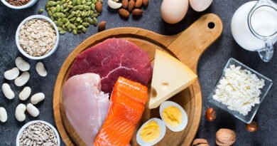 Alimentos ricos en proteína sobre una mesa: huevos, pescado, carne, legumbres, frutos secos y semillas
