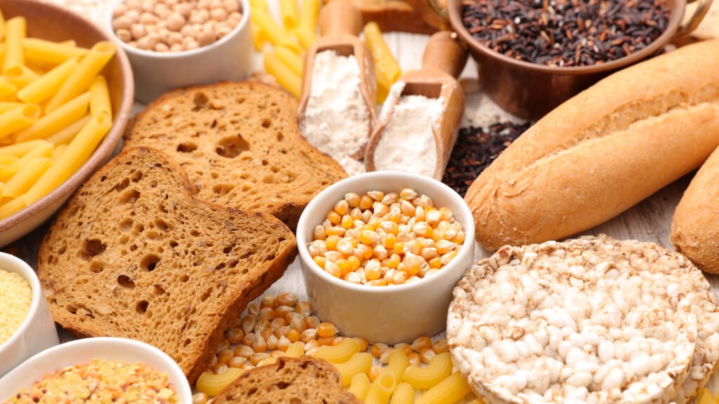 Variedad de alimentos sin TACC sobre una mesa: arroz, legumbres, frutas y harinas aptas para celíacos