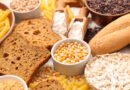 Variedad de alimentos sin TACC sobre una mesa: arroz, legumbres, frutas y harinas aptas para celíacos