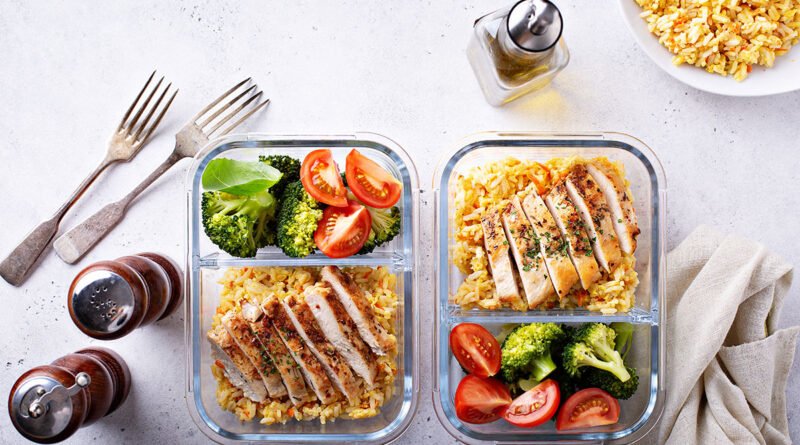 Recipientes de batch cooking con pollo, arroz integral y verduras listos para la semana