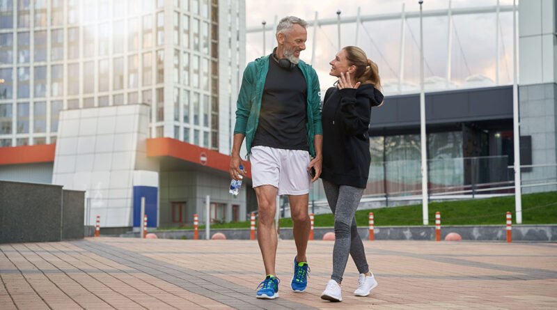 Pareja caminando al aire libre después de entrenar, hábito clave para reducir la grasa abdominal