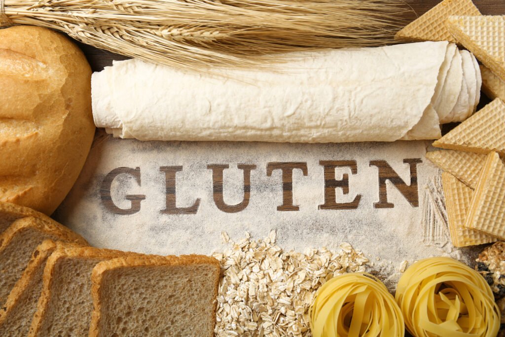 Productos de harina sobre una mesa junto a la palabra gluten, el punto de partida para buscar el logo sin TACC en las etiquetas