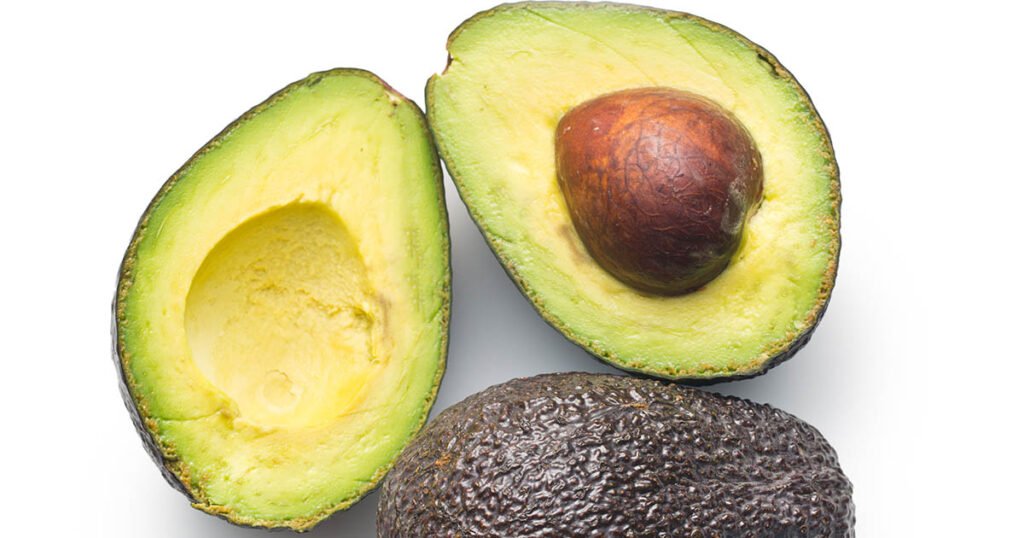 Palta o aguacate fresco cortado por la mitad mostrando el carozo