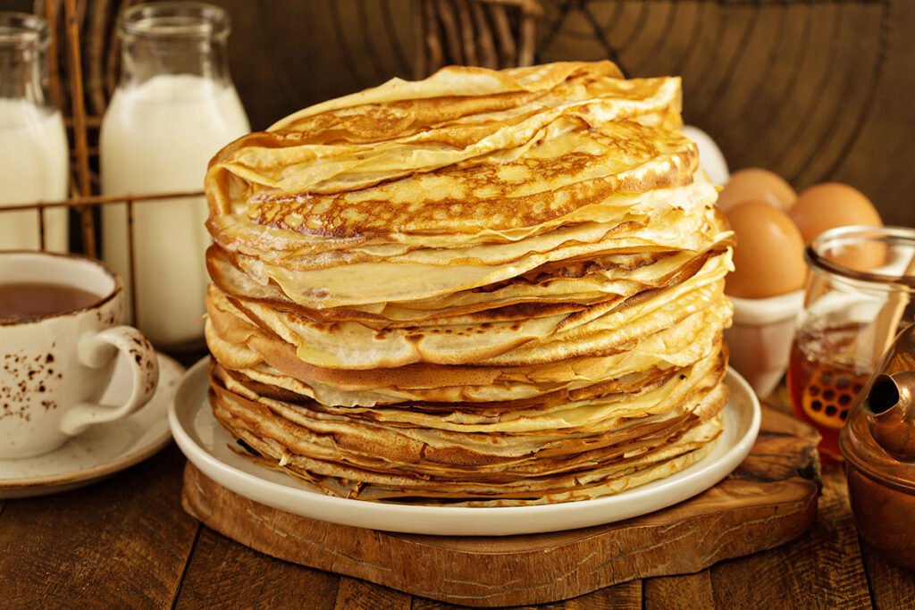 Pila de panqueques caseros finos, listos para rellenar dulces o salados