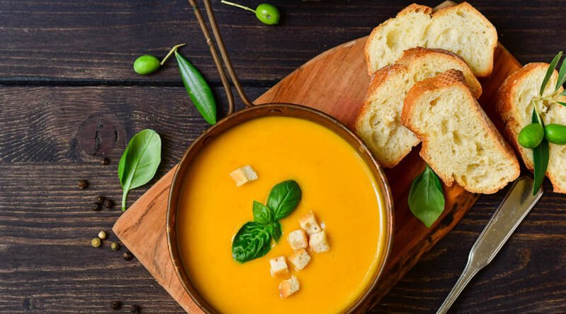 Bol de sopa de calabaza con albahaca y crackers crujientes, receta vegana
