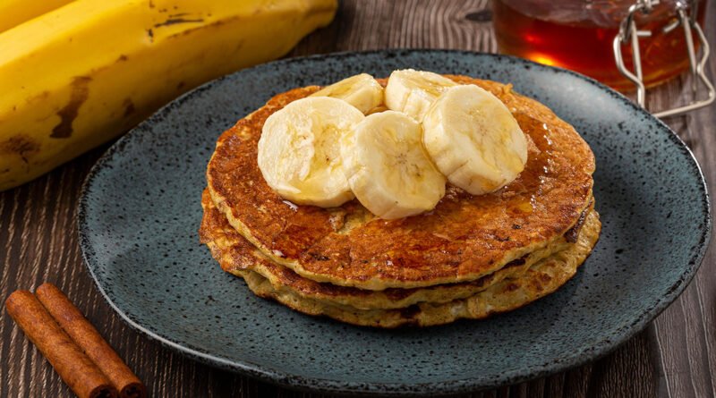 Tortitas sin harina de banana y avena, servidas con rodajas de banana y miel