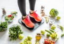 Mujer sobre balanza rodeada de alimentos saludables
