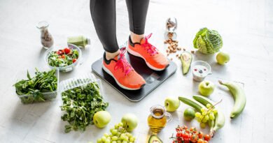 Mujer sobre balanza rodeada de alimentos saludables