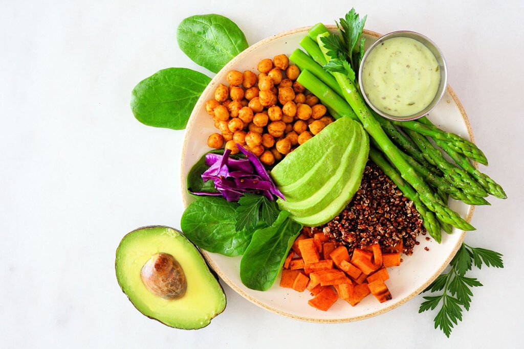 Bowl con quinoa, garbanzos, batata, espárragos y palta, ejemplo de plato basado en plantas