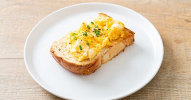 Huevos revueltos cremosos servidos sobre una tostada de pan integral