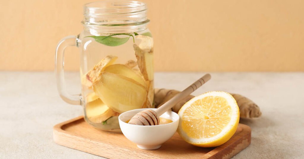 Bebida de jengibre fresco con limón y miel sobre tabla de madera
