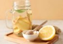 Bebida de jengibre fresco con limón y miel sobre tabla de madera