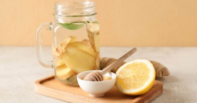 Bebida de jengibre fresco con limón y miel sobre tabla de madera