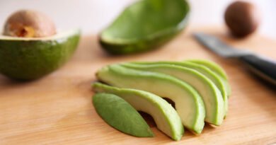 Palta fresca cortada en fetas sobre tabla de cortar