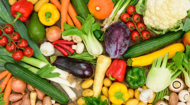 Variedad de frutas y verduras frescas de feria sobre un puesto de mercado